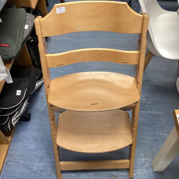 Vintage wooden shop seat ladder in a warehouse setting.