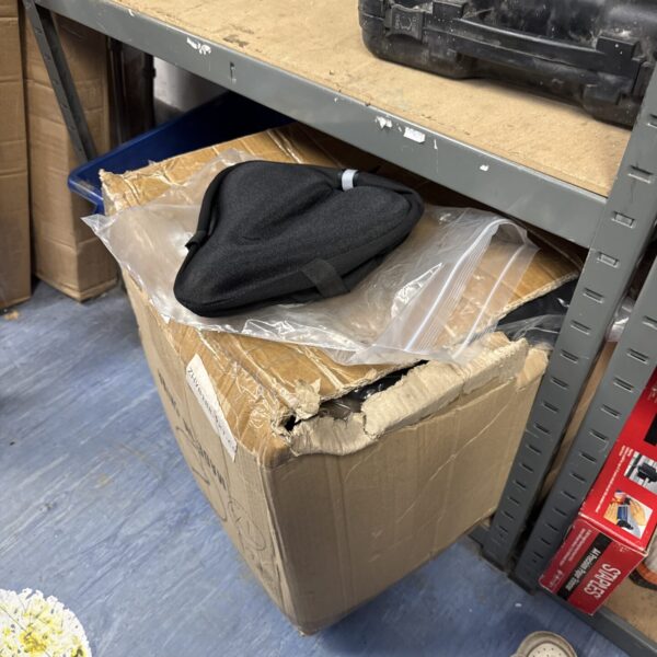 Large lot of gel padded bicycle saddle covers in a cardboard box.
