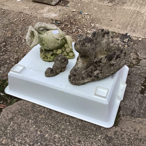 Weathered concrete garden ornaments featuring a teddy bear and frog.