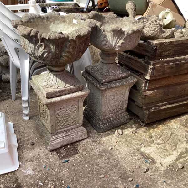 Pair of weathered stone effect garden planters for outdoor use.