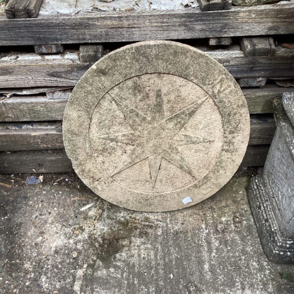Rustic stone compass base for garden decoration.