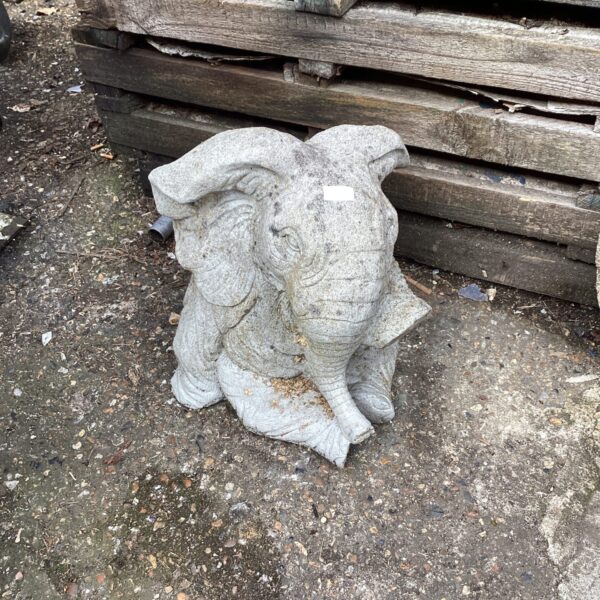 Large concrete garden elephant statue in a garden setting.