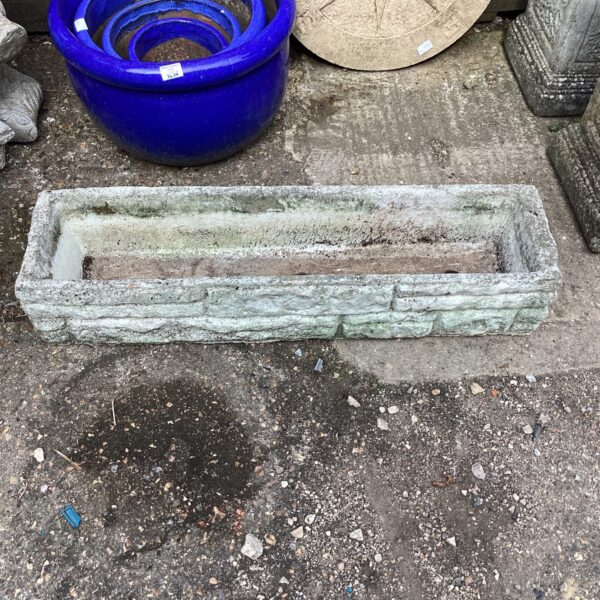 Weathered stone garden trough for displaying plants outdoors.