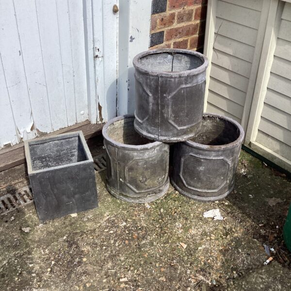 Four weathered stone effect garden planters for outdoor use.