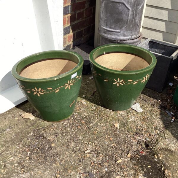 Two green glazed garden planters with floral design.