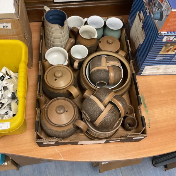 Mixed lot of Denby stoneware dinner service pieces on display.