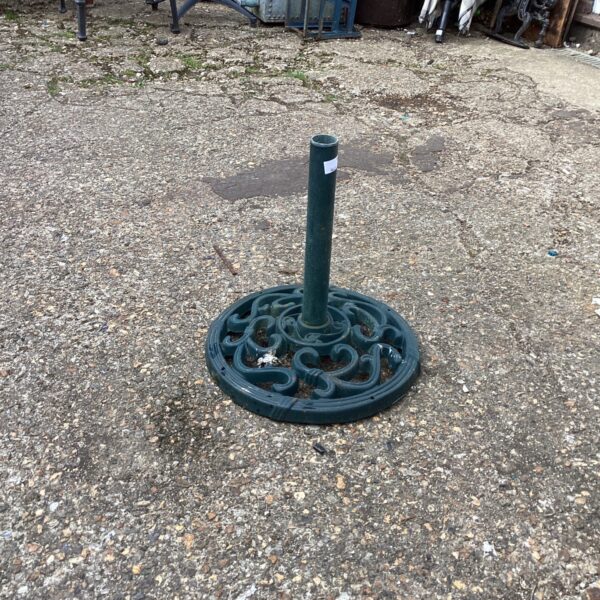 Decorative metal parasol base with floral pattern for garden use.