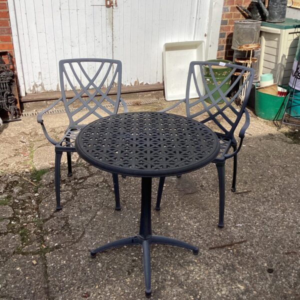 Dark metal garden furniture set with table and two chairs.