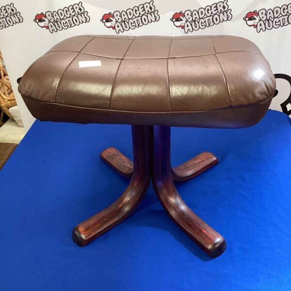 Vintage brown leather footrest with sculpted wooden base.