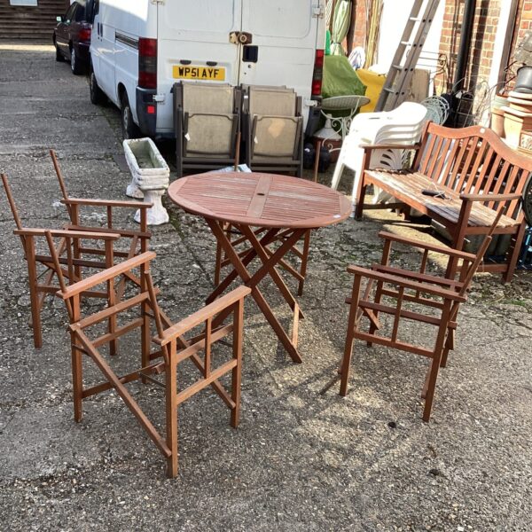 Vintage teak garden table and four chair frames in need of restoration.