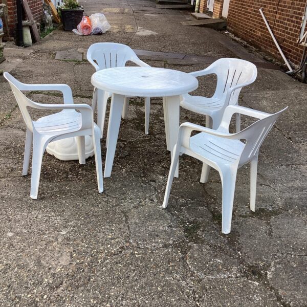 White plastic garden furniture set with table and four chairs.
