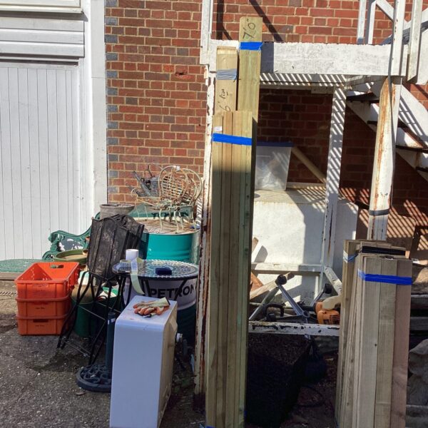 Stacked timber bundles in a garden setting for DIY projects.