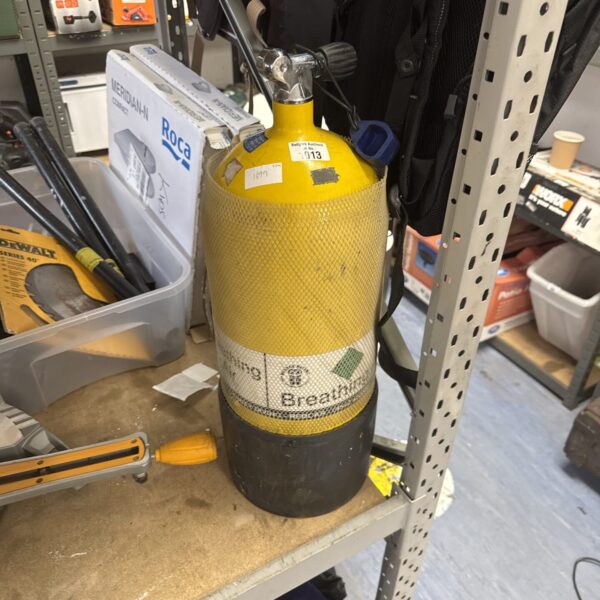 Yellow breathing air canister with valve, showing signs of use.