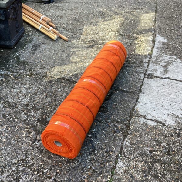 Vibrant orange curtain fabric roll for home decor projects.