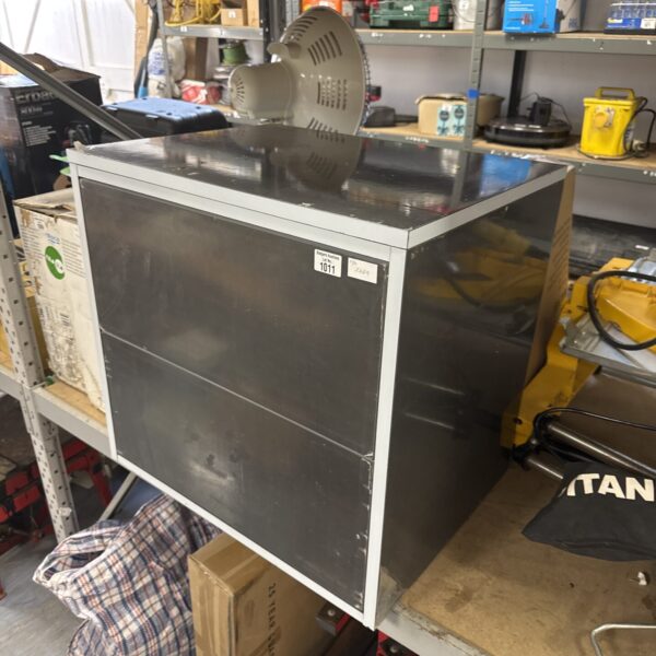 Stainless steel wall mounted drawer unit in a workshop setting.