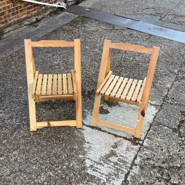 Pair of vintage pine folding chairs for garden or patio use.