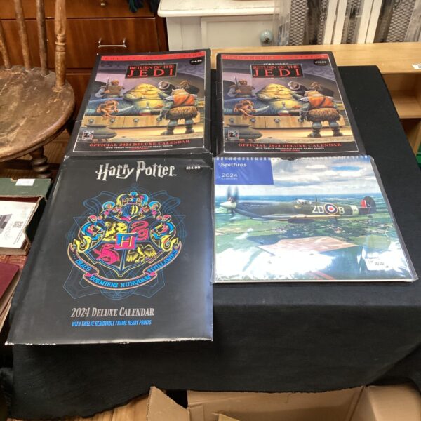 Four 2024 calendars featuring Star Wars and Harry Potter designs.