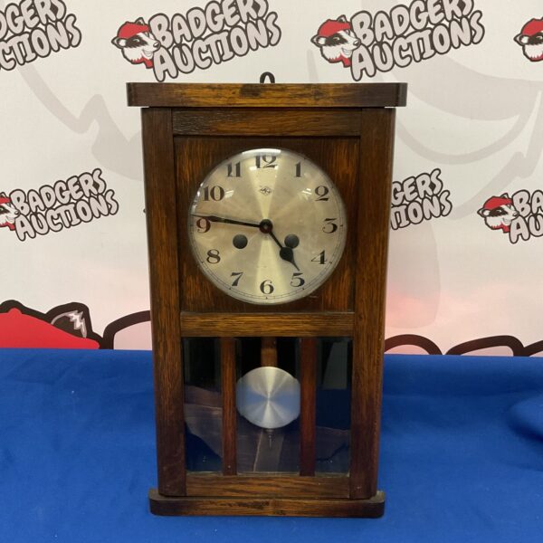 Vintage Doldonia wall clock with Roman numerals and wooden case.