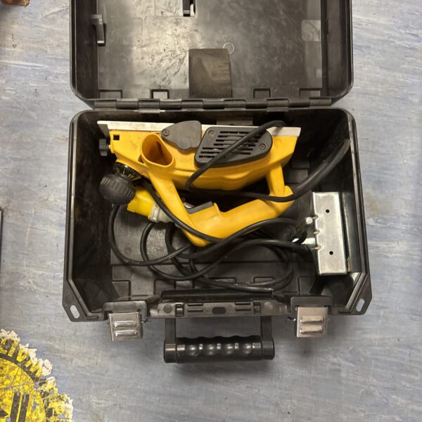 Dewalt electric planer in original carrying case, showing signs of use.