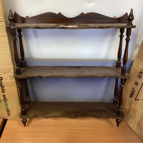Vintage mahogany wall shelf with carved details.
