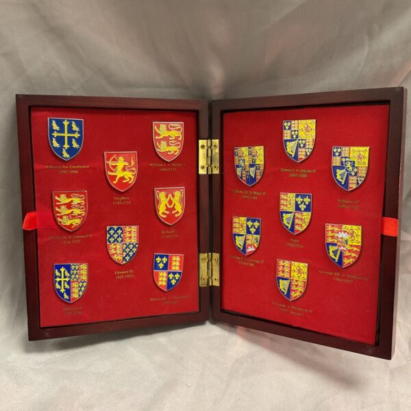 Open velvet case displaying British royal heraldry enamel badge set.