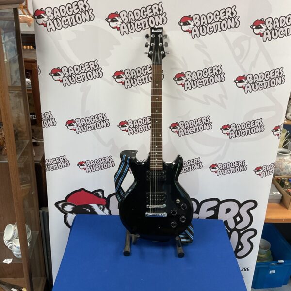 Black Ibanez Gio electric guitar, ideal for beginner musicians.