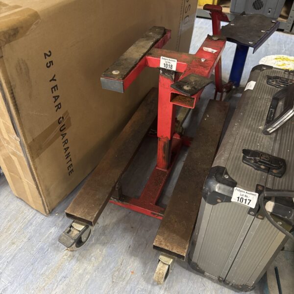 Red motorcycle lift stand for rear maintenance and repair.