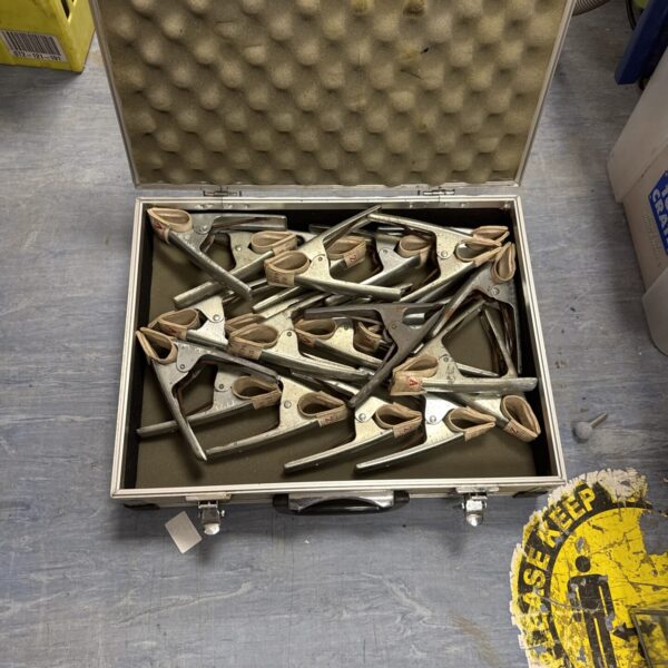 Metal market stall clamps stored in a flight case for transport.
