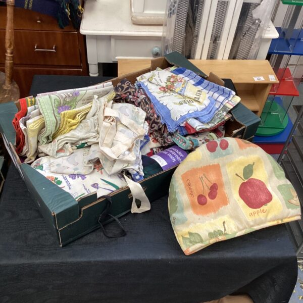 Vintage tea towels and a tea cosy in a box.