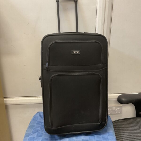 Blue Slazenger suitcase with wheels and pull handle.