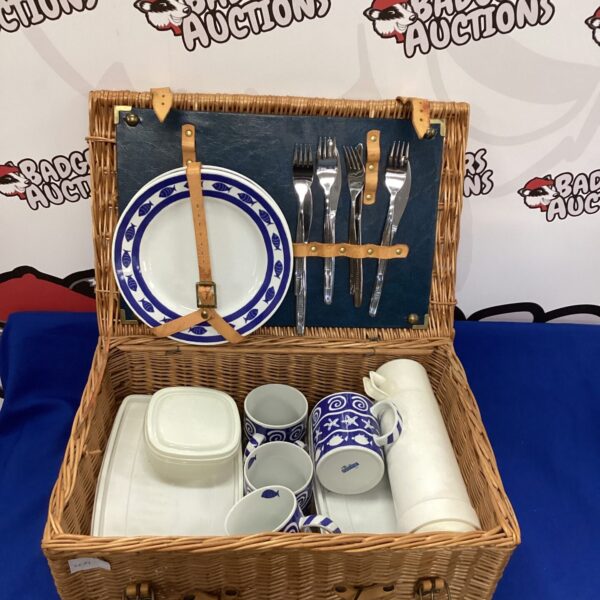Open wicker picnic hamper with contents displayed.