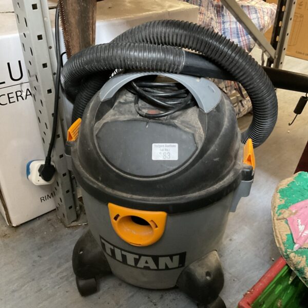 Front view of a used Titan vacuum cleaner with hose attached.