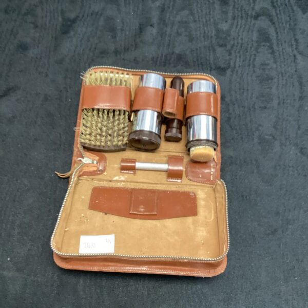 Open vintage gentlemans grooming kit with leather case and tools.