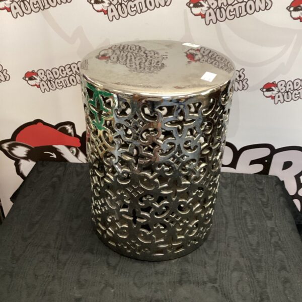 Decorative metal stool with intricate pierced metalwork design.