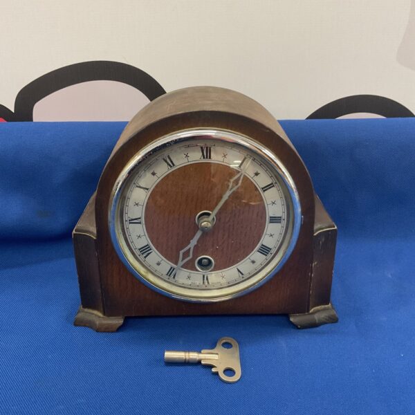 Vintage oak mantle clock with Roman numerals and key.