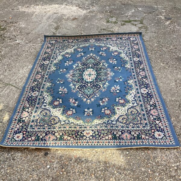 Vintage blue rug with intricate floral pattern.