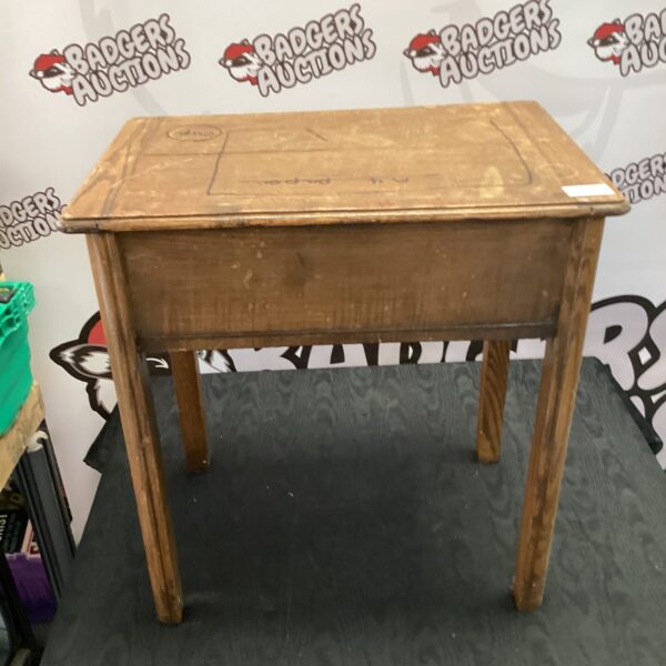 Vintage wooden child's desk with a worn surface.