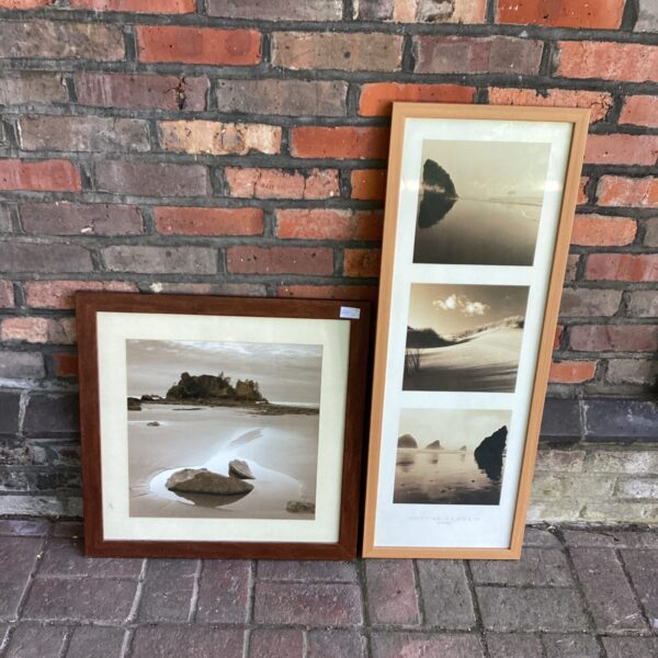 Pair of framed seaside prints depicting calm coastal scenes.