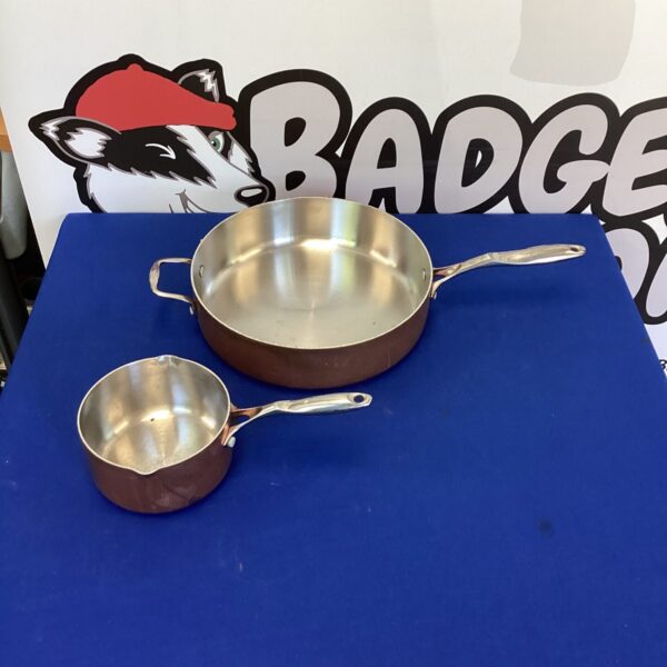 Two vintage Stella copper pans with long handles.