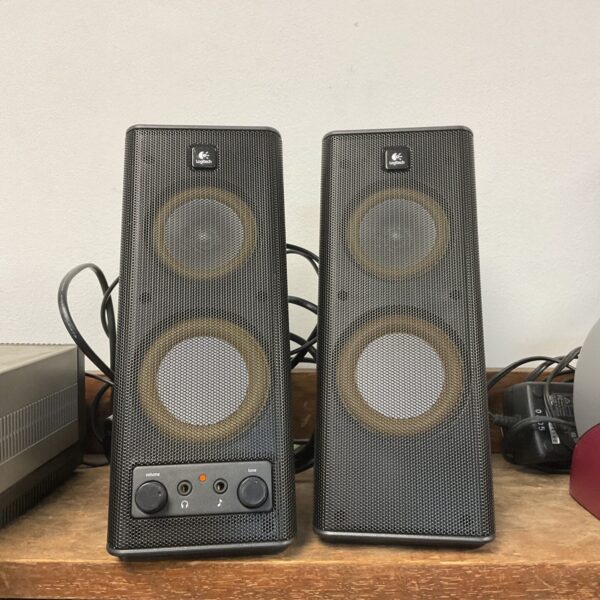 Pair of black Logitech multimedia speakers on a desk.