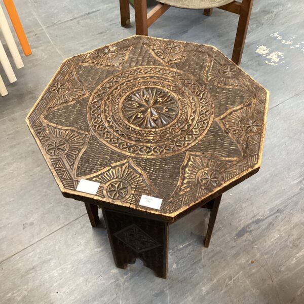 Intricate carving on a hexagonal Indian table.