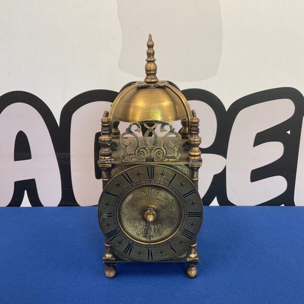 Vintage brass lantern clock on display, classic timepiece.