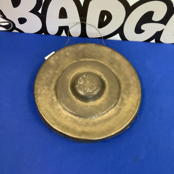 Vintage copper dinner gong with a warm patina.