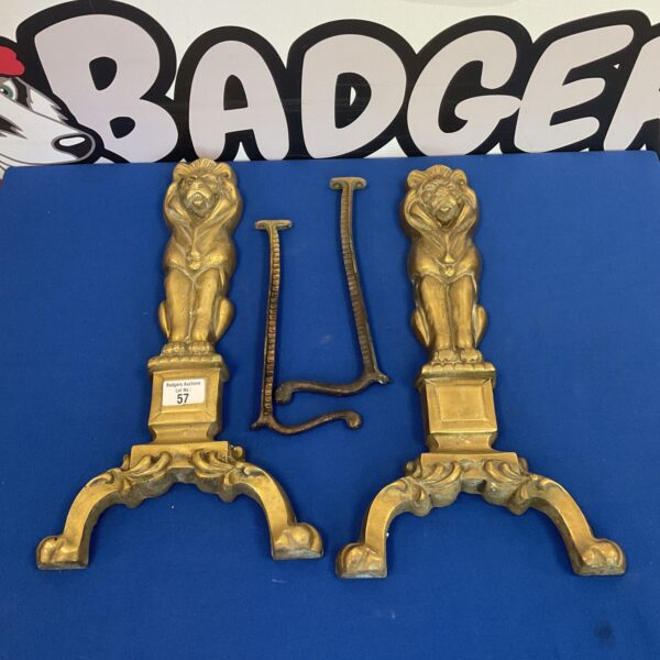 Antique brass lion fire dogs, a decorative fireplace accessory.
