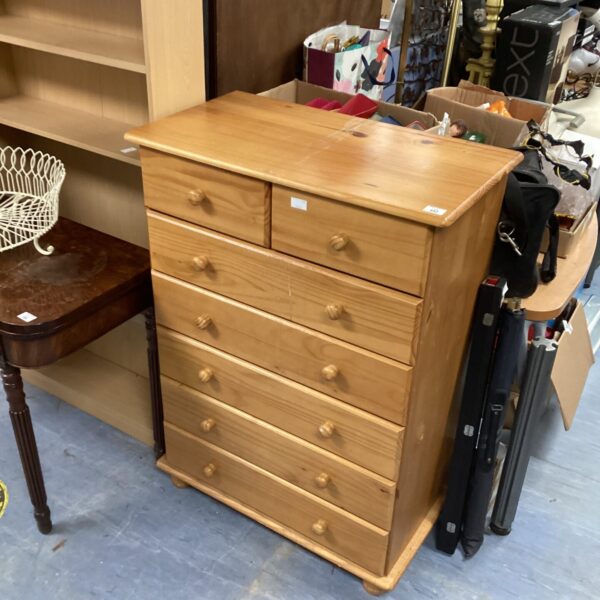 Vintage pine chest of drawers with five drawers for bedroom storage.