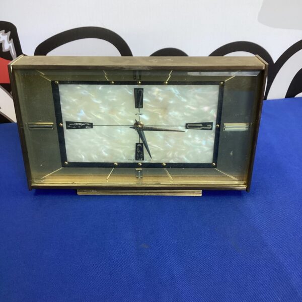 Front view of a vintage Metamec mantle clock with wooden casing.