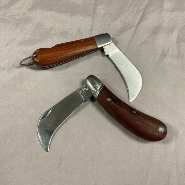 Vintage pruning pocket knife with wooden handle and curved blade.