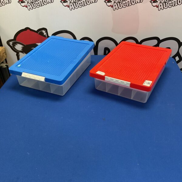 Red and blue Lego storage boxes on a table.