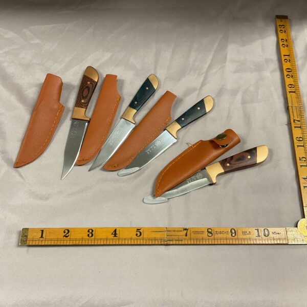 Lot of four small sheath knives with wooden handles.