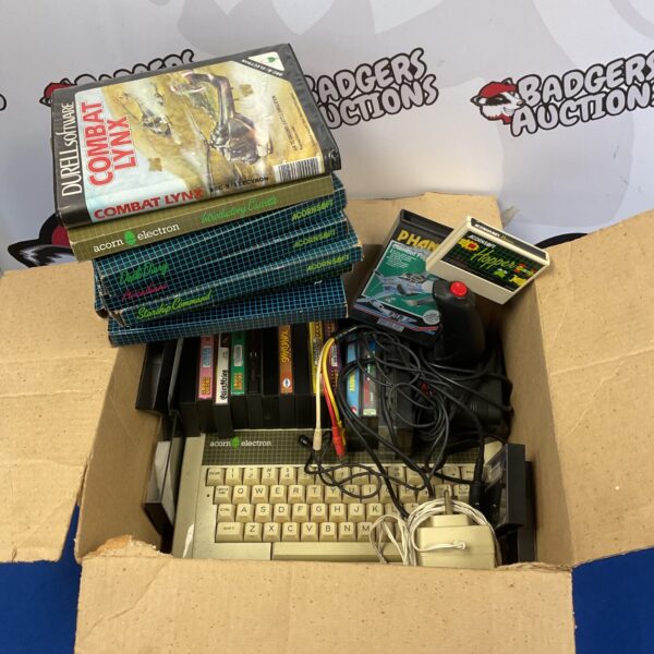 Vintage Acorn Electron computer with game cartridges and accessories.